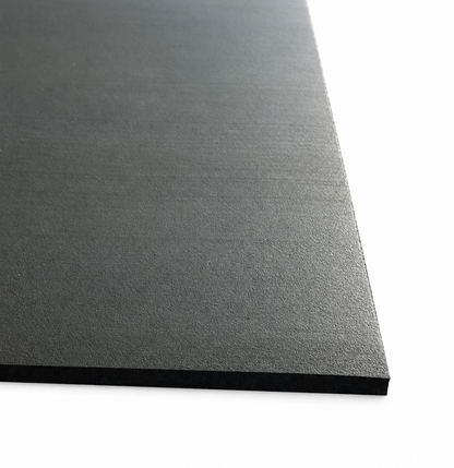 A close-up of a black textured rectangular rubber mat shown at an angle against a white background.